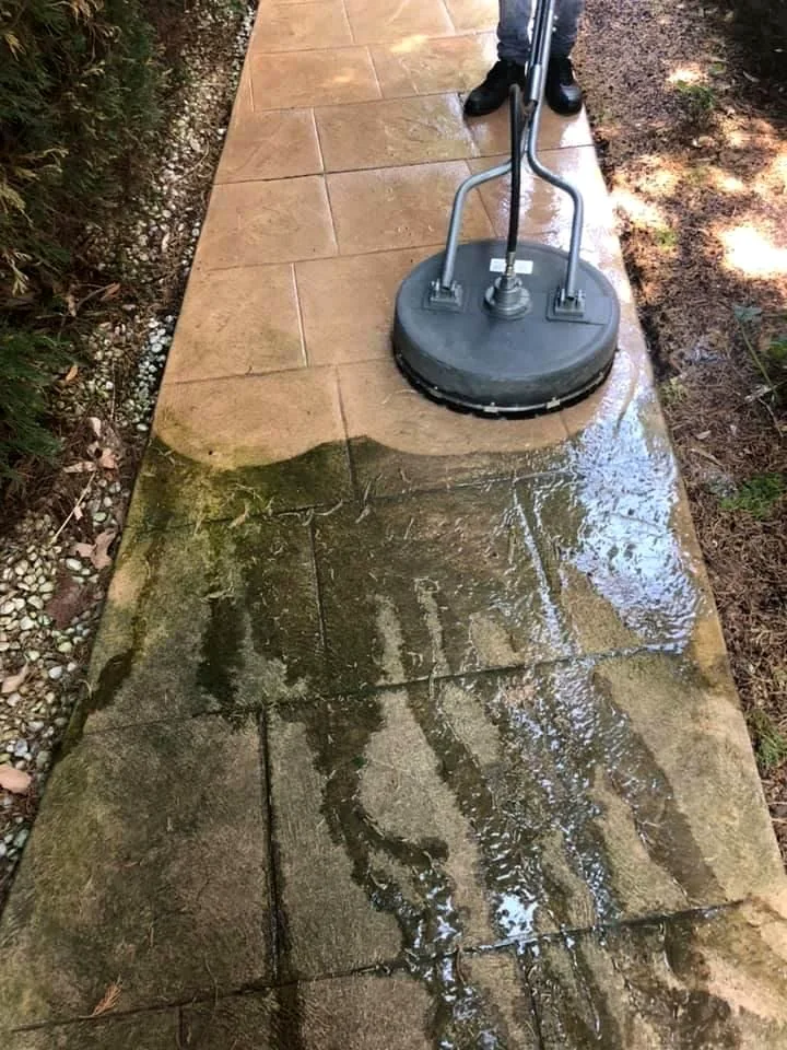 Pressure washing revealing a cleaner paved surface