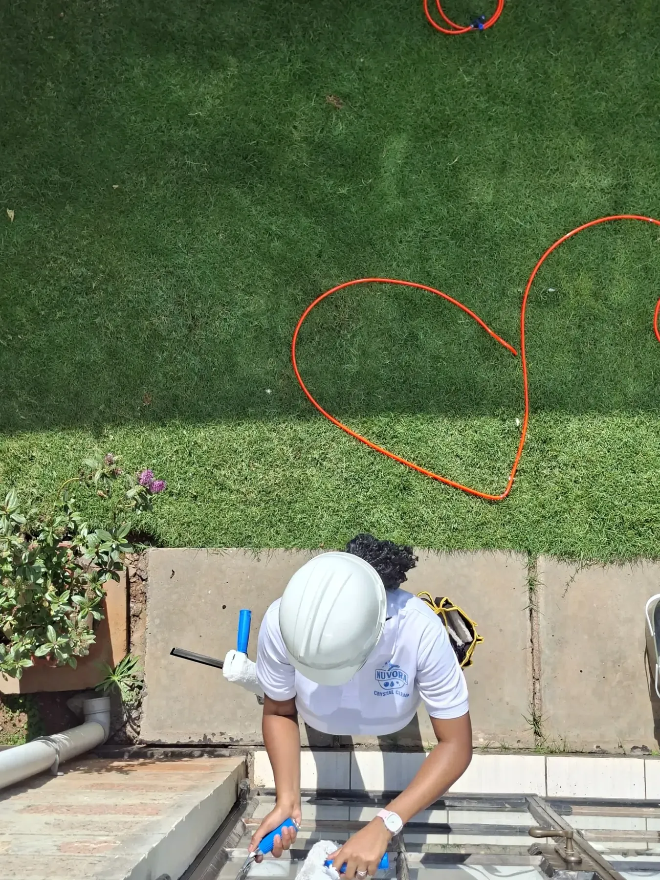 Dirty Nuvora technician with professional high-reach window-cleaning equipment